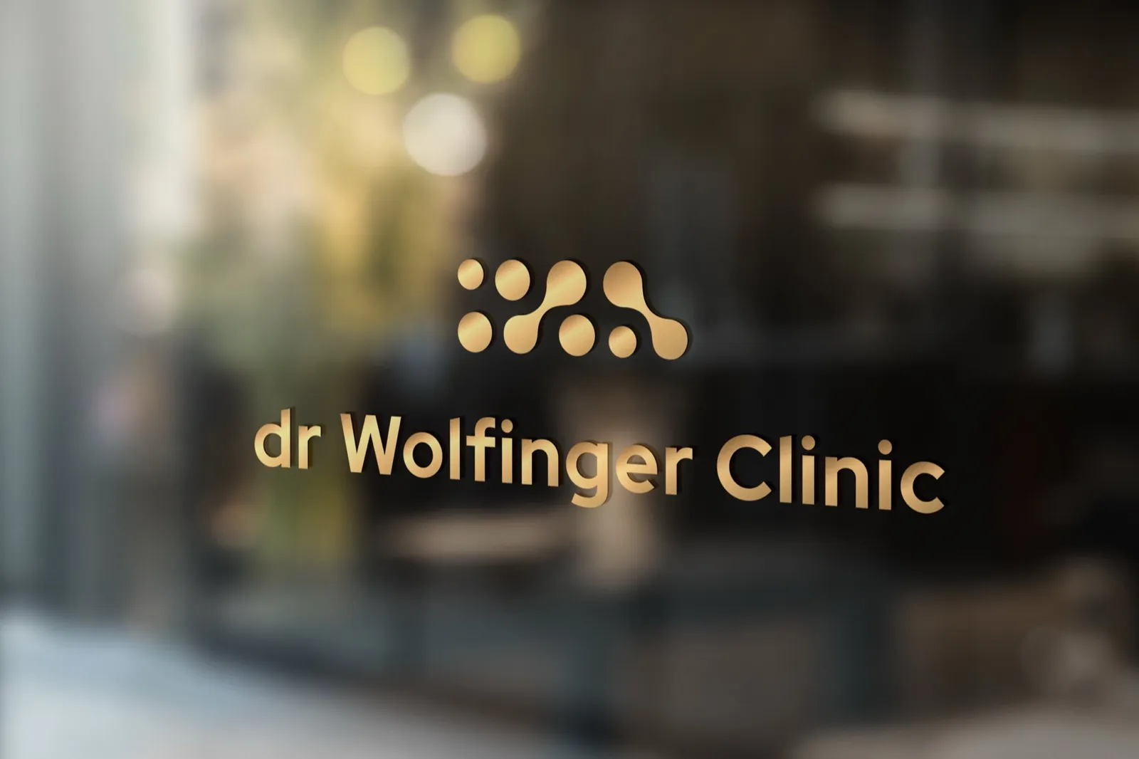 Złoty szyld dr Wolfinger Clinic na szkle w recepcji